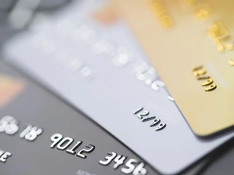 Cartões de crédito sobre mesa ilustrando impactos financeiros de dívida ativa.
