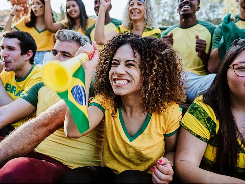 Torcedores brasileiros vibrando com a seleção em clima de Copa do Mundo.