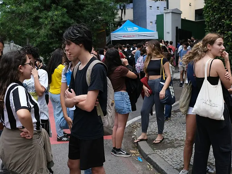 Estudantes em frente a escola pública; programa incentiva formação de novos professores.