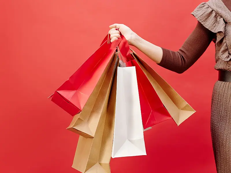 Pessoa segurando sacolas de compras representando promoções e consumo