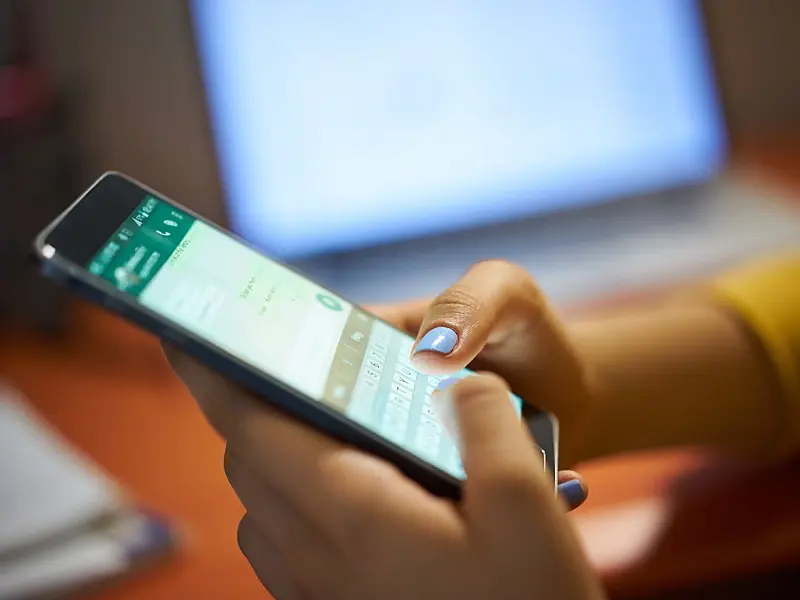 Usuária utiliza aplicativo de mensagens no celular durante a noite