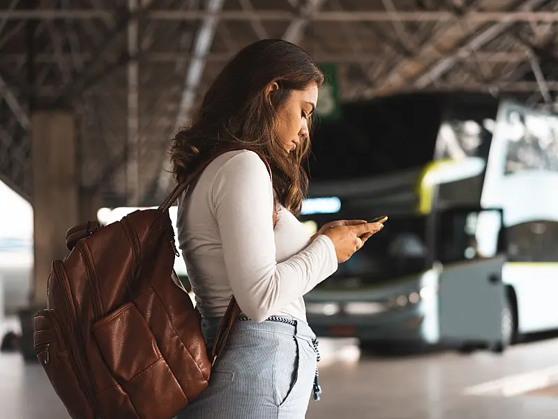 Passageira aguarda ônibus em terminal enquanto regras exigem documento válido para embarque