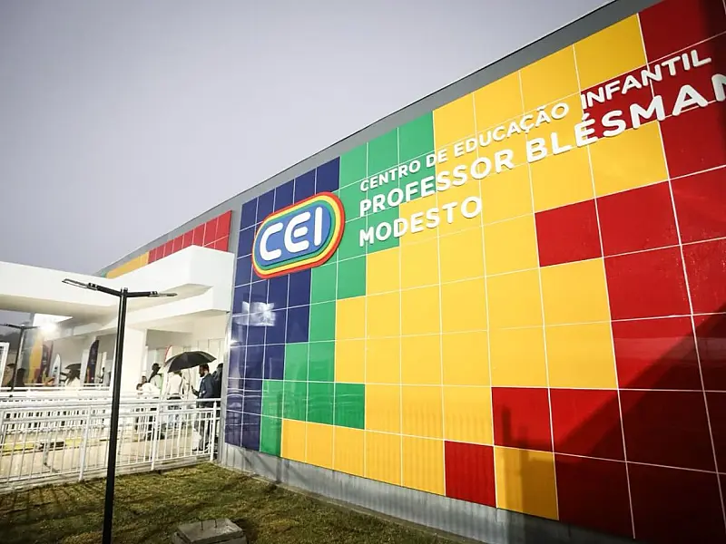 Fachada colorida do novo Centro de Educação Infantil em Buíque, com autoridades e moradores reunidos na entrada durante a cerimônia de inauguração oficial