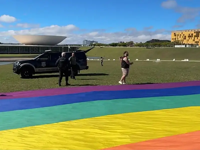 Ativistas seguram as pontas de grande bandeira do arco-íris antes da abordagem policial na Esplanada dos Ministérios