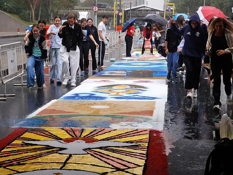 Voluntários utilizaram materiais coloridos para dar forma aos desenhos sacros sobre o asfalto da capital fluminense
