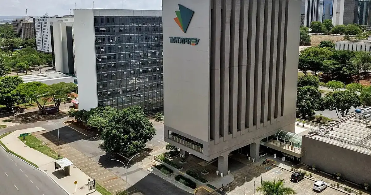 Fachada externa em plano médio de um prédio comercial moderno de vidro e concreto, que abriga as instalações da sede da Dataprev