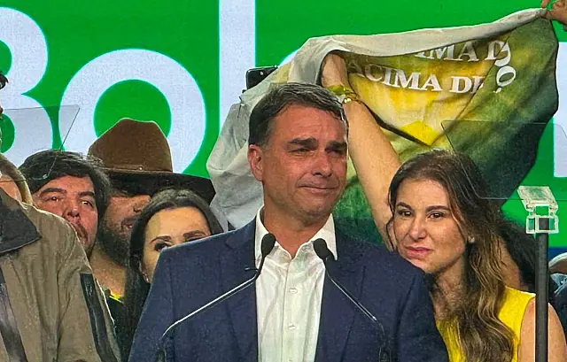 O senador Flávio Bolsonaro discursando no microfone durante uma convenção partidária