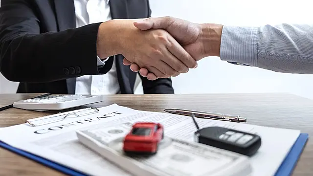 Cliente assinando documentos de apólice veicular em balcão de atendimento