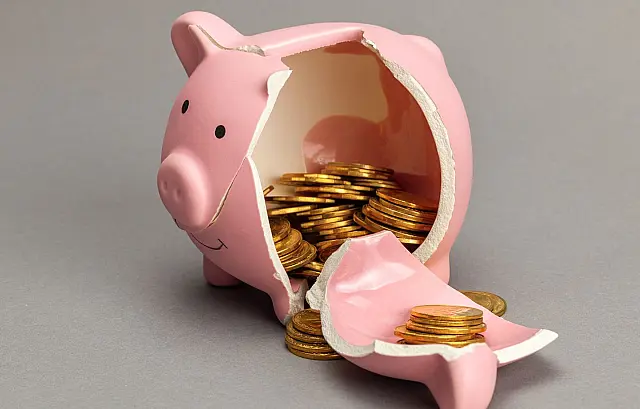 Cofre em formato de porquinho quebrado simbolizando a retirada de reservas financeiras