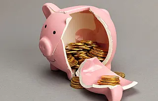 Cofre em formato de porquinho quebrado simbolizando a retirada de reservas financeiras