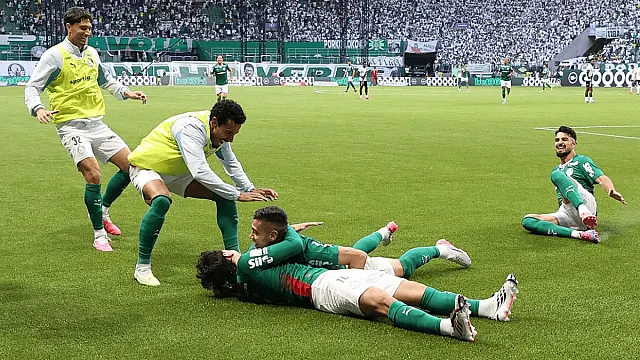 Jogadores do Palmeiras comemorando gol abraçados no gramado durante partida do campeonato
