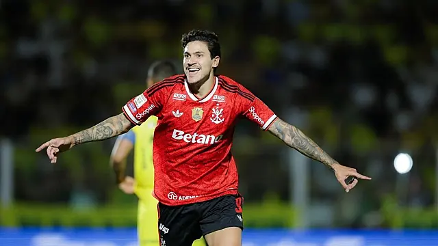 Jogador Pedro do Flamengo comemora gol em campo usando uniforme oficial do clube