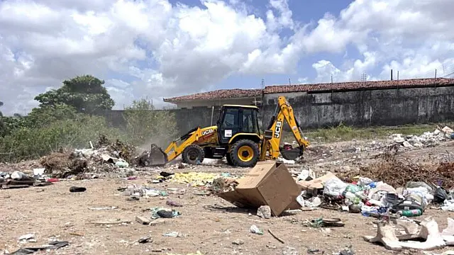 Retroescavadeira durante serviço de limpeza urbana